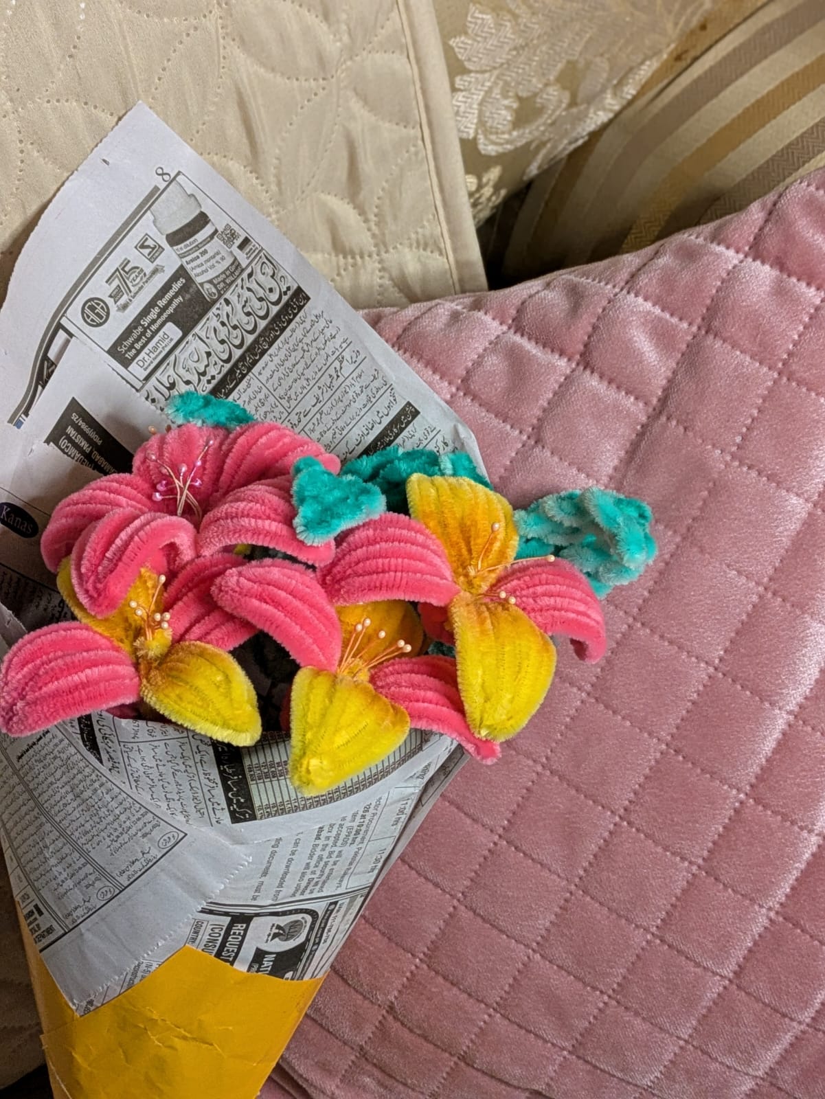 Close front composition of a pink and yellow handmade pipe cleaner flower bouquet