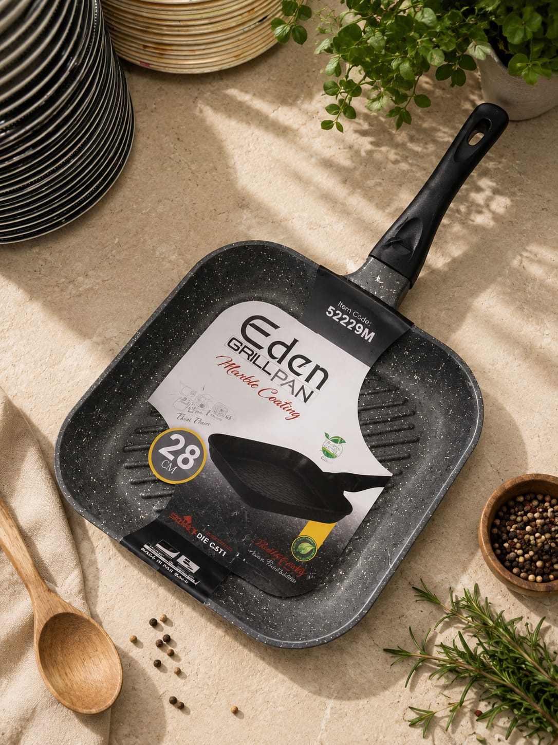 Eden marble coating grill pan photographed with rosemary, peppercorns and a wooden spoon